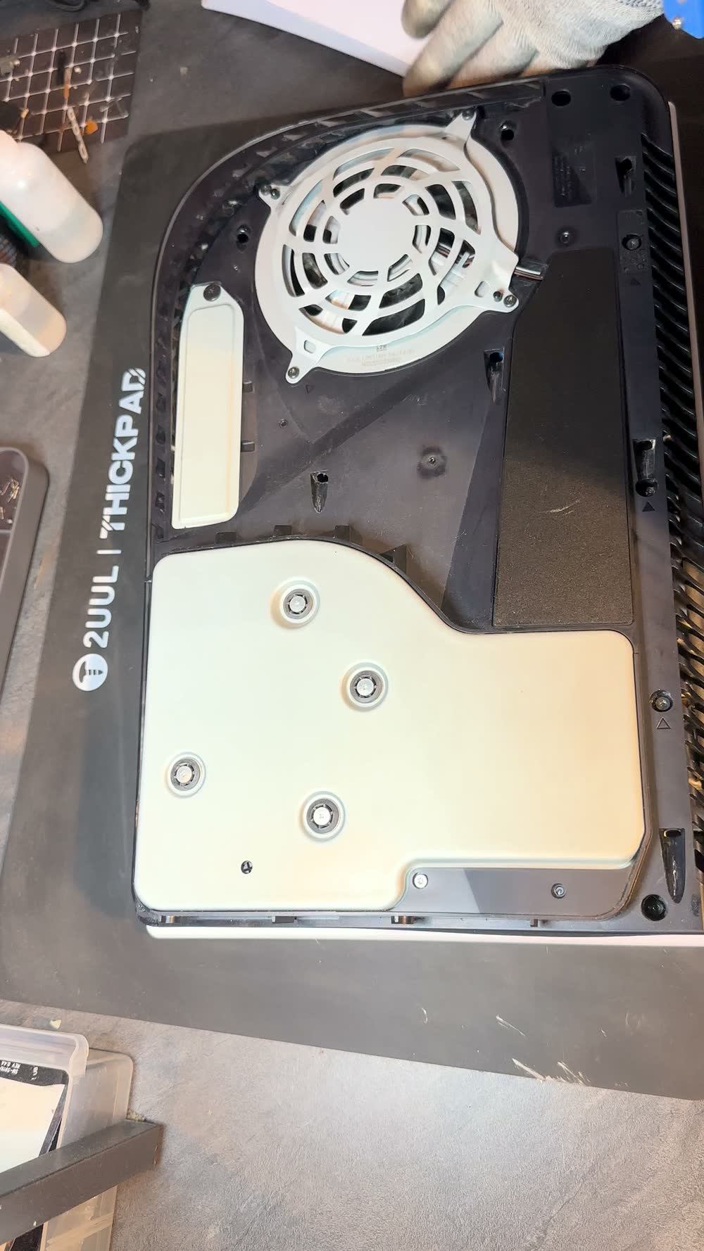 PS5 ouverte, ventilateur et plaque blanche visibles